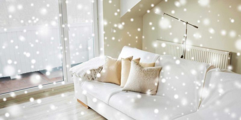 Cozy living room with white sofa in snowfall.